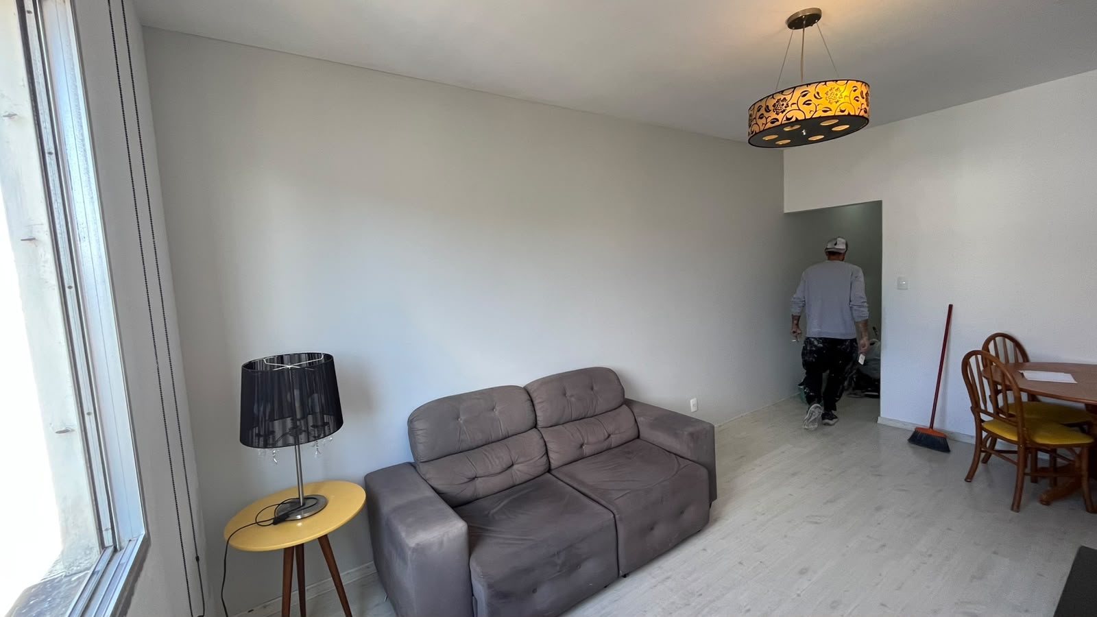 Sala de estar com paredes em cinza claro neutro após pintura profissional